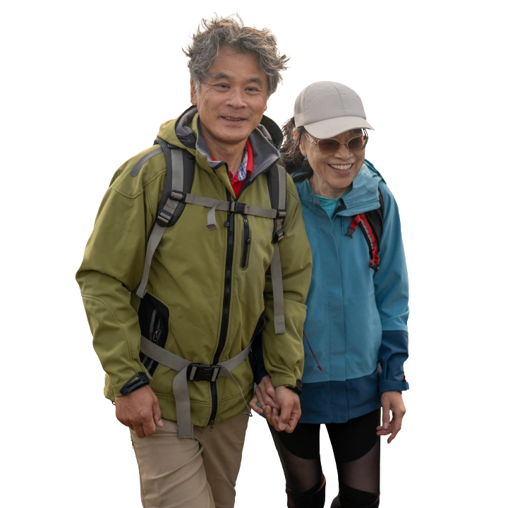 middle-aged couple in rain jackets walking on the beach